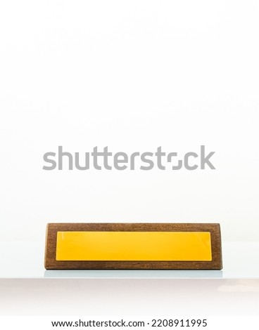 Wooden yellow business office plate in white background with title blank copy paste space. Yellow empty space position plate in office isolated in white background Royalty-Free Stock Photo #2208911995