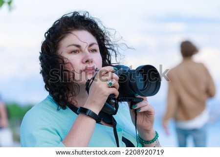 A woman with a photo camera in her hands.
