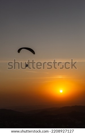 Paraglider Flying Over the Mountain at Sunset