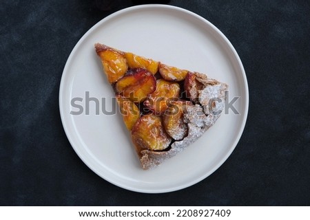 slice of plum pie on the blue and black background . Fruit pie. Tart.