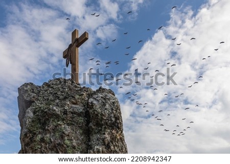 Crucifix symbol and beads on top rock mountain hill blue sky background. Crucifixion Of Jesus
