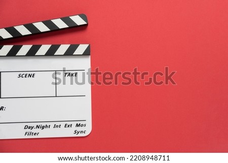 movie clapper on red table background ; film, cinema and video photography concept