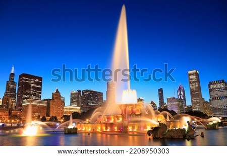 Chicago skyline illuminated at dusk with Buckingham fountain on the foreground, Illinois, USA
