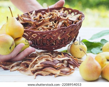 The season for harvesting dried fruits for future use. Woman's hands hold dried pears. Natural background with dried fruits. Juicy fragrant pears against the backdrop of nature and dried pears. Royalty-Free Stock Photo #2208954053
