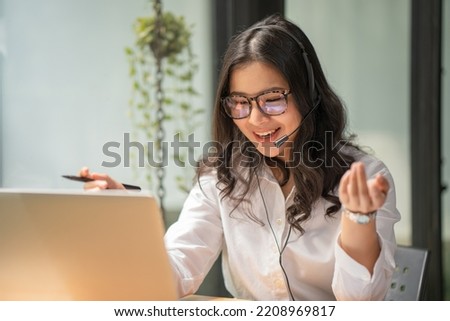 Smiling young female call center worker with headphones. Royalty-Free Stock Photo #2208969817