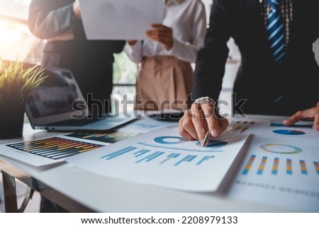 Businesspeople pointing to graphs and charts, thinking and analyzing various data in reports market growth to plan new sales strategies to increase productivity.