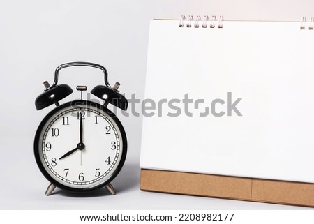 Blank paper spiral calendar for mockup template advertising and branding with clock on gray background.