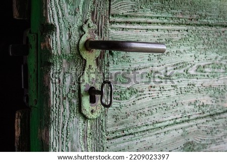 A lock with a big key in an old rustic wooden door Royalty-Free Stock Photo #2209023397