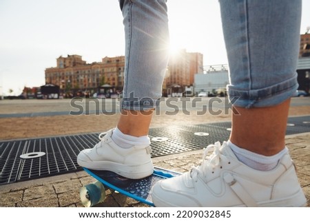 A beautiful young girl with dreadlocks rides a skateboard in sunny weather. generation z