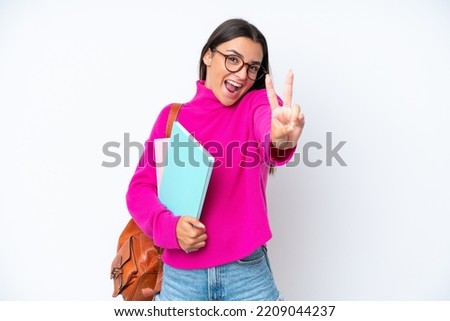 Young student woman isolated on white background smiling and showing victory sign