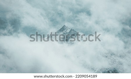 Mountain peak peeking through clouds Royalty-Free Stock Photo #2209054189