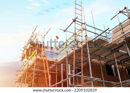 Scaffolding erected around houses in a new housing development Royalty-Free Stock Photo #2209102839