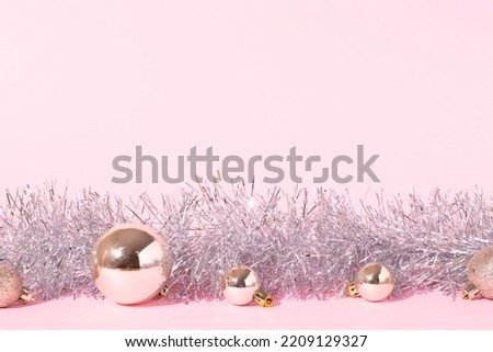 Christmas composition made of silver shiny decorations on pink background. Minimal winter, new year, or Christmas concept.