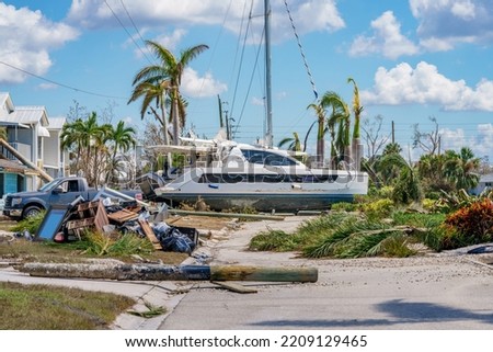 Image of a catamaran resting on a residential neighborhood street after Hurricane Ian Fort Myers FL Royalty-Free Stock Photo #2209129465