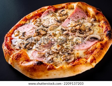 Pizza with Mozzarella cheese, ham, tomato sauce, onion, pepper, mushrooms on black