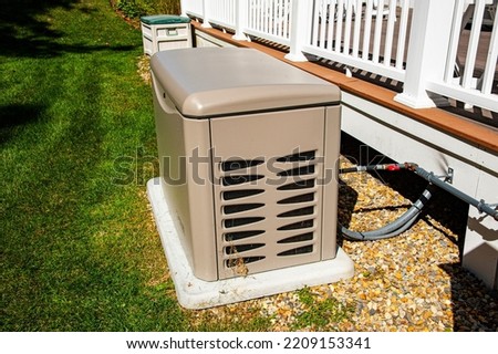 Residential standby generator on concrete pad Royalty-Free Stock Photo #2209153341