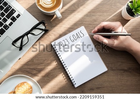 Man is writing 2023 goals for new year resolutions plan. Royalty-Free Stock Photo #2209159351