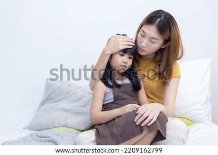 Asian Mother Hug Her Sick Daughter on Her Bed Royalty-Free Stock Photo #2209162799