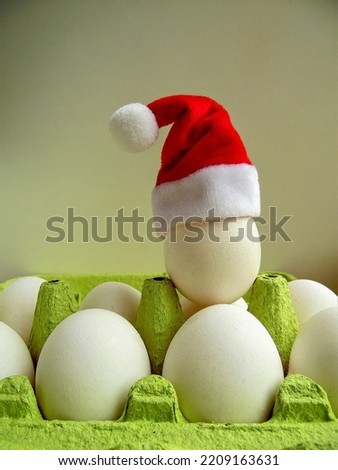 Santa's hat on a white egg, white eggs in  tray and Santa's hat on one of the eggs, Christmas theme