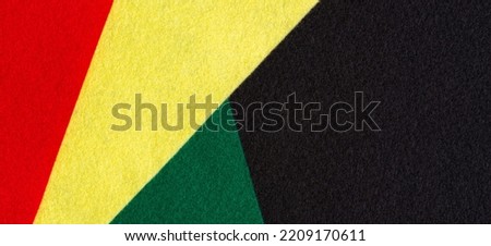 Geometric felt fabric textile background in black, red, yellow, green colors. Black History Month color background with copy space for text.