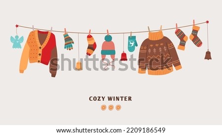 Cozy winter banner with knitted warm sweaters on rope. Seasonal clothes and accessories, socks and mittens, christmas toys. Cute warmy vector elements on string Royalty-Free Stock Photo #2209186549