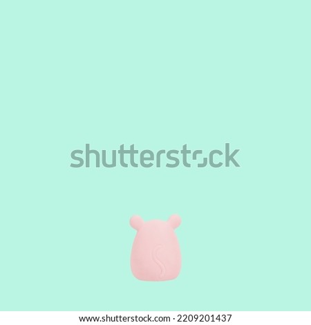Cute pink hamster is on bottom on bright green background minimal art. Easter spring concept idea with copy space