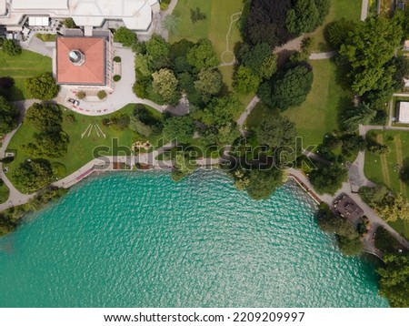 Ciani Park in the South switzerland in the summer of Ticino during the pandemic and the green lake next to the green trees and the houses Royalty-Free Stock Photo #2209209997