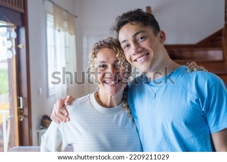 Portrait of middle age mother spend time with teenager son, relatives people hugging at home, adult attentive millennial grateful child wrapped in a plaid or warm sweater loving mommy caring Royalty-Free Stock Photo #2209211029