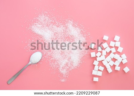 Scattered sugar and sugar cubes on a pink background, flat lay. Royalty-Free Stock Photo #2209229087