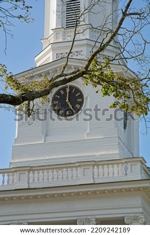 Clock tower in white church steeple of First Parish in Lexington Massachusetts. Black wooden turret clock face Royalty-Free Stock Photo #2209242189