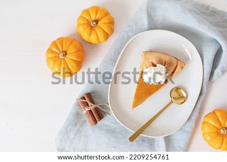 Pumpkin pie baking ingredients with pumpkins, nuts, seasonal spices and piece of pie. Thanksgiving and autumn holidays celebration concept. Top view, flatlay