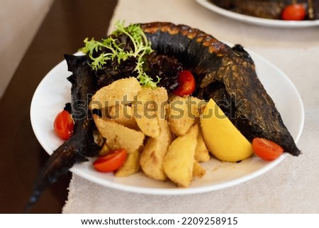Fresh raw fish pike perch on foil for baking with vegetables, prepared for cooking, on a wooden background