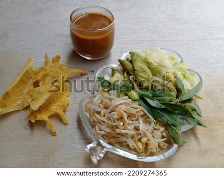 Pecel. Some vegetables in the form of cabbage, bean sprouts, cucumber, turi or agathi flowers and basil are served with peyek or peanut crackers and peanut sauce. Indonesian food.
