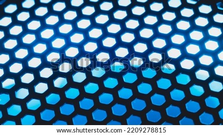 Blue light shines through the ventilation grid holes of computer air cooling system. abstract background