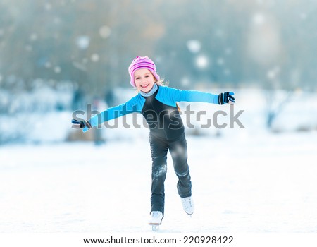 pretty  cheerful little girl in thermal suits skating  outdoors