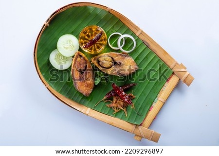 Ilish bhaji for Panta ilish, Bengali new year festive dish. Fried Hilsha slices with chilli, tomato and onion. Hilsa fry is popular in pohela boishakh. on kula. Royalty-Free Stock Photo #2209296897
