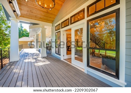 exterior photographs of a rich and luxurious craftsman home on a golf course with bright sunshine blue sky and lush landscaping