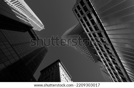 Tall skyscraper modern office buildings in Manhattan photographed from bottom to top, amazing wide angle view of this massive constructions. Travel to New York, black and white photo. Royalty-Free Stock Photo #2209303017