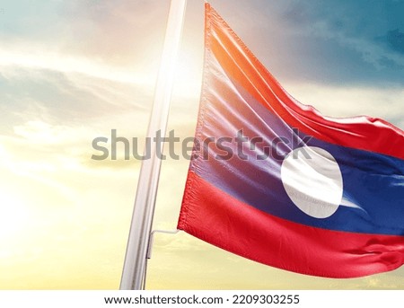 Laos national flag cloth fabric waving on the sky with beautiful sunlight - Image