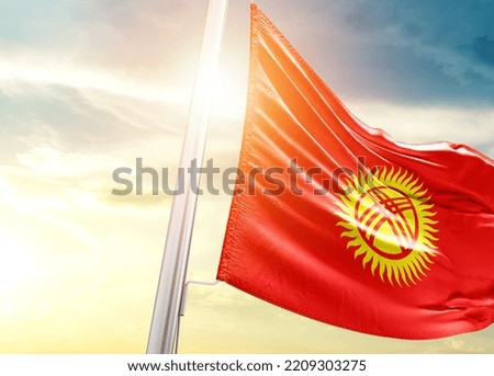Kyrgyzstan national flag cloth fabric waving on the sky with beautiful sunlight - Image