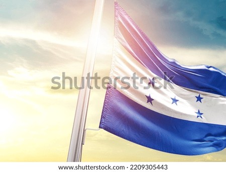 Honduras national flag cloth fabric waving on the sky with beautiful sunlight - Image