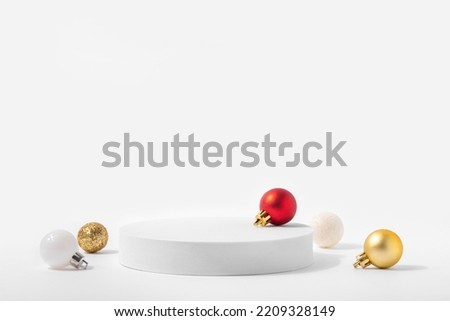 Cosmetic background for Christmas and winter holiday. White podium and christmas balls on white background.