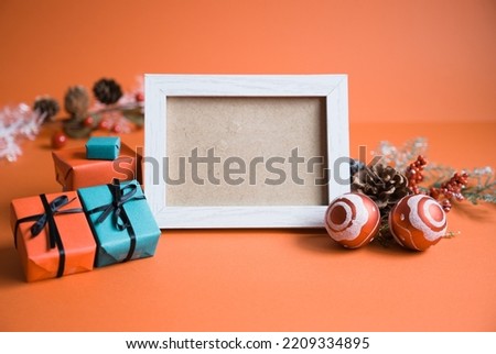Red background photo with Christmas decorations around a photo frame turned sideways