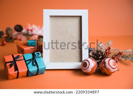 Red background photo with Christmas decorations around a picture frame oriented vertically