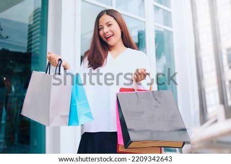 Beautiful Asian woman holding shopping bag, Cheerful woman with shopping bag.