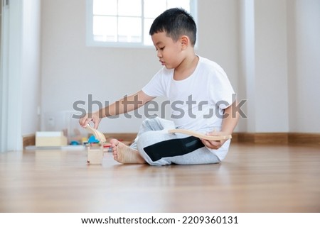 Asian boy playing wood block toy on the floor at home. 