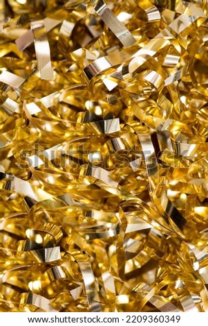 A pile of laminated tinsel of golden color close-up Royalty-Free Stock Photo #2209360349