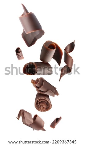 Many flying chocolate curls on white background Royalty-Free Stock Photo #2209367345