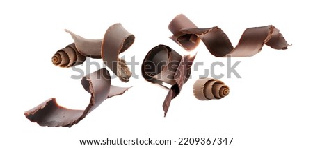 Many flying chocolate curls on white background Royalty-Free Stock Photo #2209367347