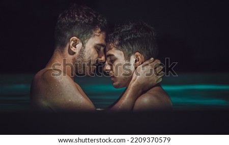 Gay couple relaxing in swimming pool. LGBT. Two young men kissing and hugging. Young men romantic family in love. Happiness concept Royalty-Free Stock Photo #2209370579